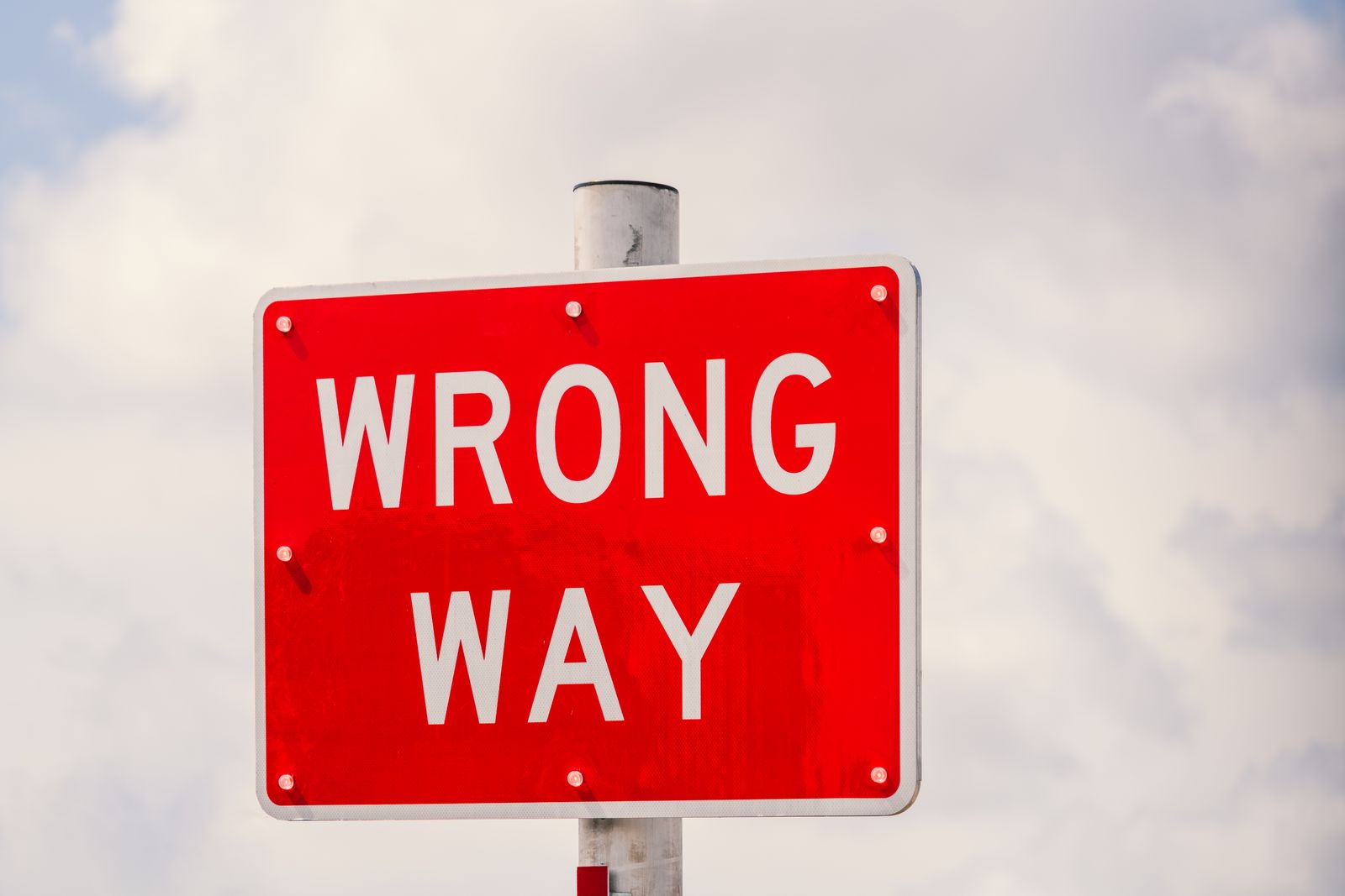 Señal roja con el texto Wrong Way sobre un cielo claro